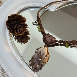 Handmade dark brown macrame amethyst crystal necklace on mirror background